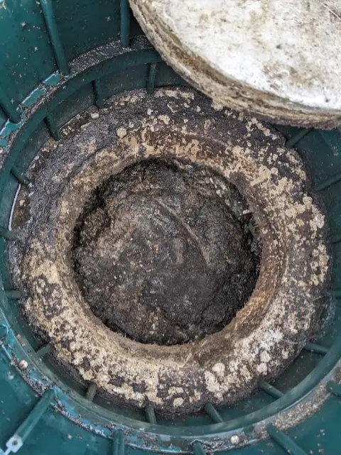 view looking down an open riser on a septic tank